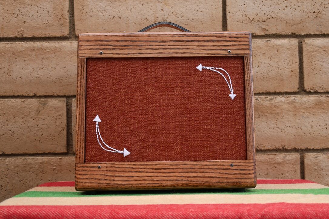Oak cabinet with rust grill cloth and white arrows