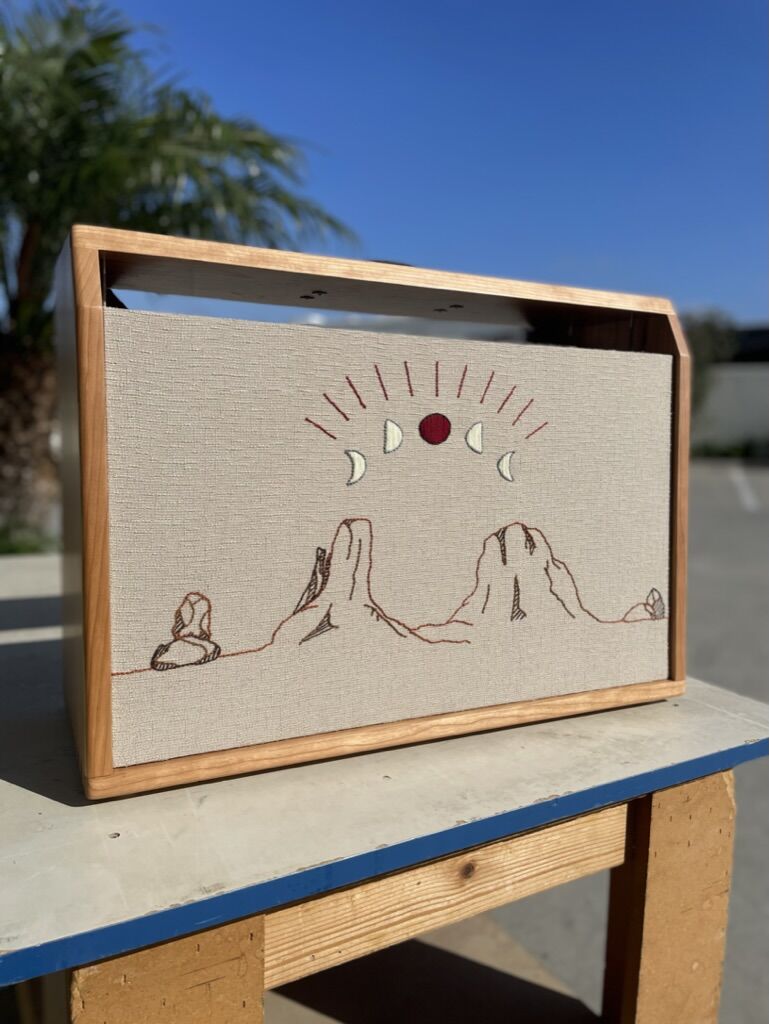Cabinet with an embroidered desert scene and rising sun