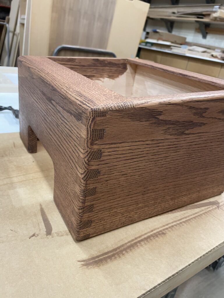 Close-up of a hand-cut box joint on an oak cabinet