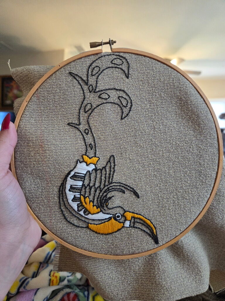 A toucan design in progress in an embroidery hoop