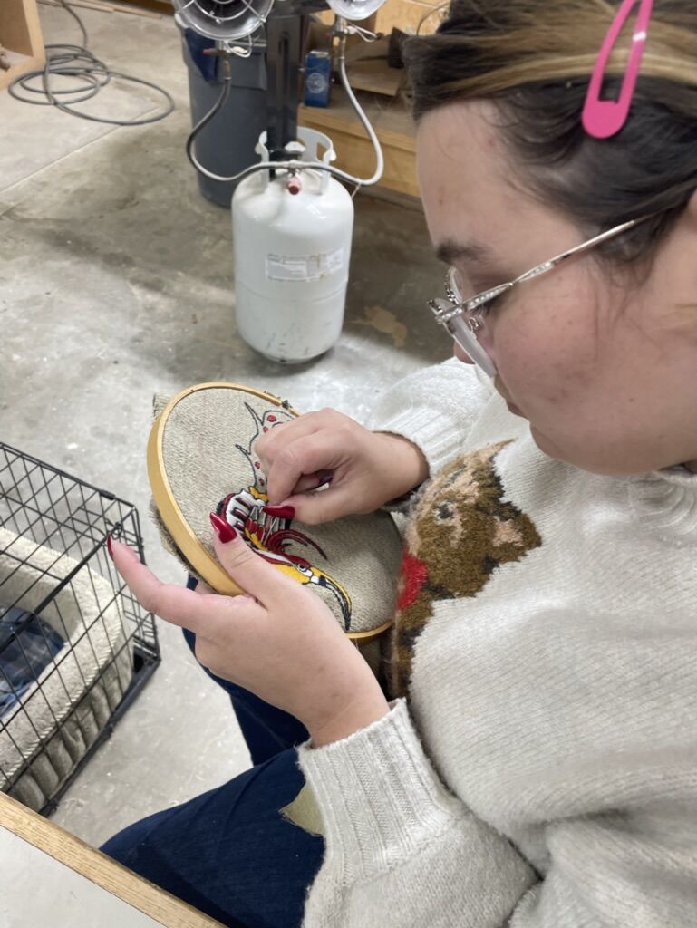 Stitching a design by hand in an embroidery hoop