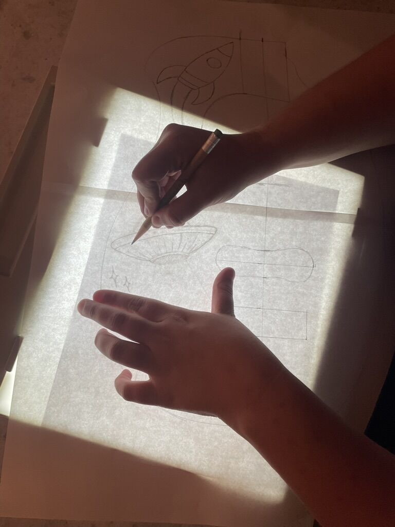 Tracing an embroidery design onto grill cloth over a light box