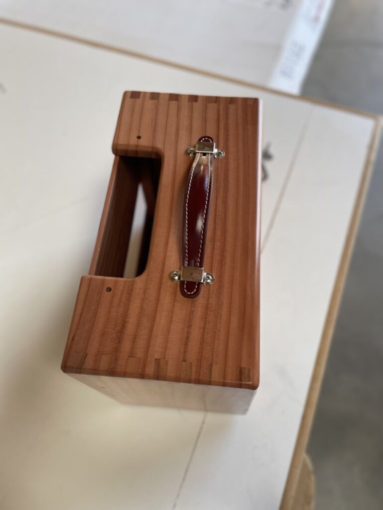Leather handle on top of a hardwood cabinet
