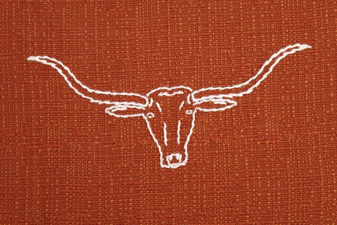 White longhorn stitched on rust grill cloth
