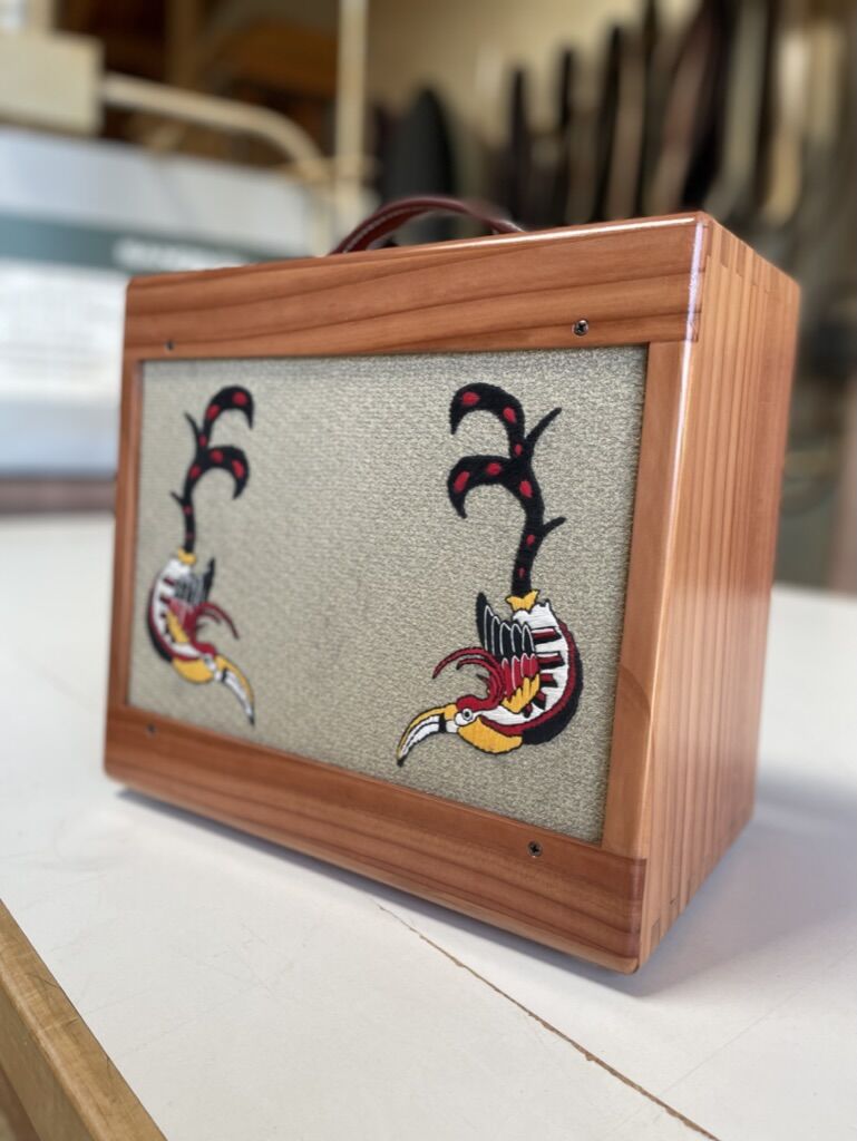 Finished redwood cabinet with leather handle and toucan embroidery